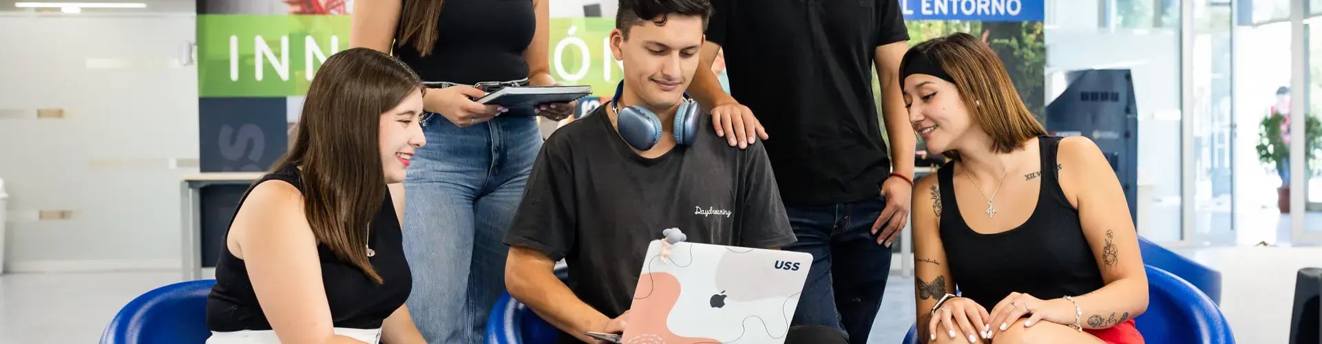 Estudiantes universitarios reunidos trabajando en un computador portátil